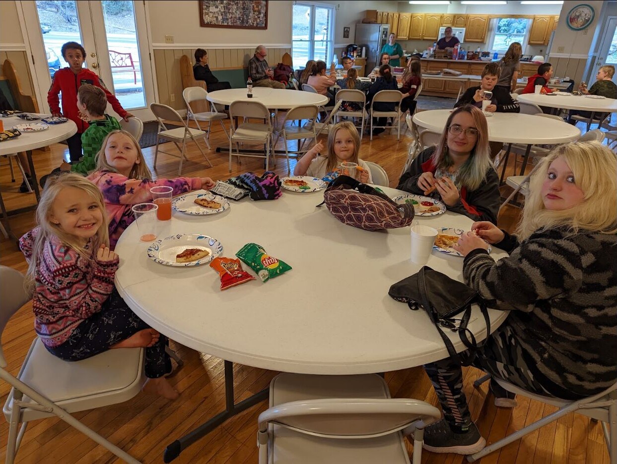 Children and adults sharing a meal in the fellowship hall